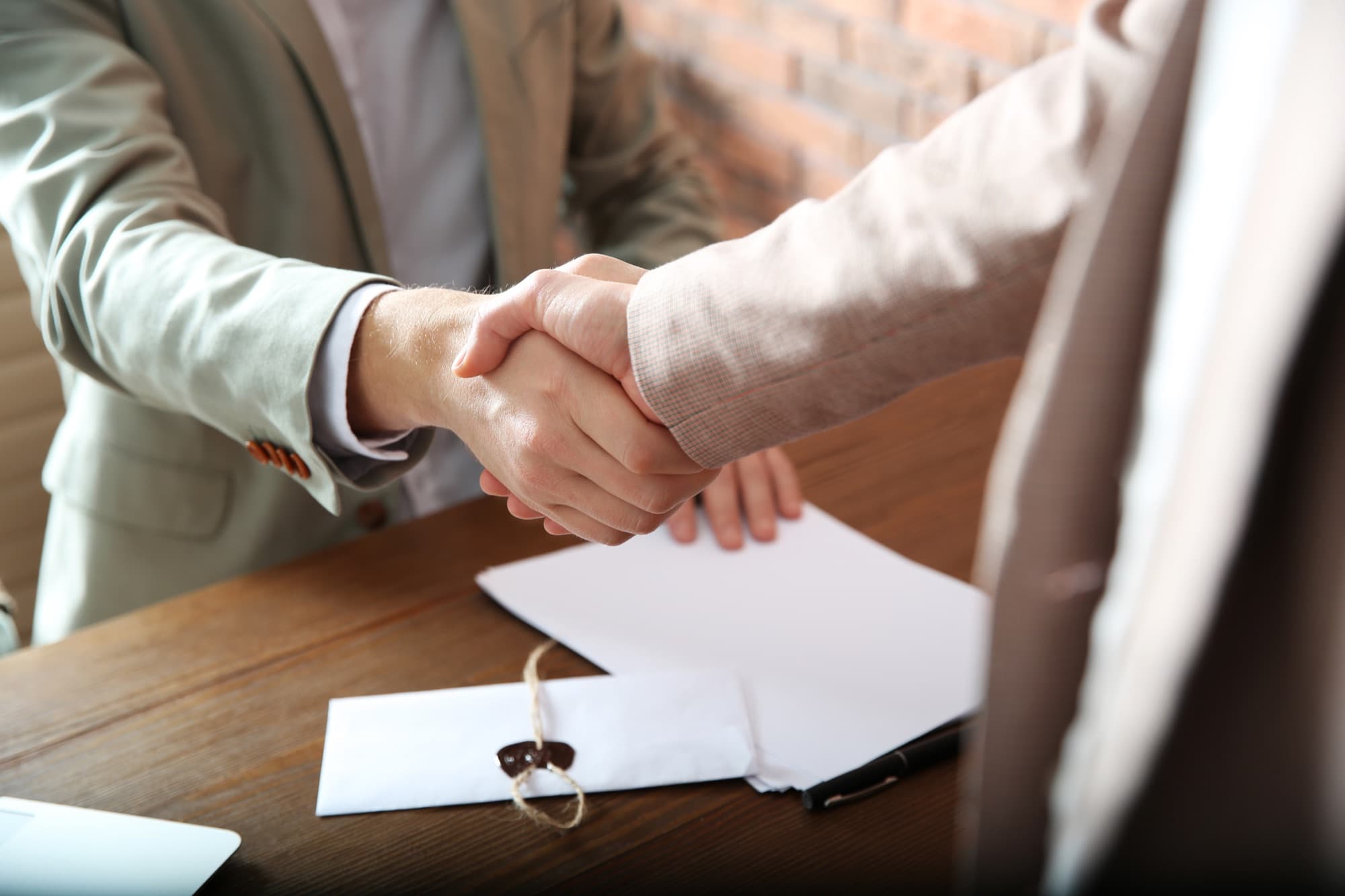 Client and notary shaking hands after signing documents